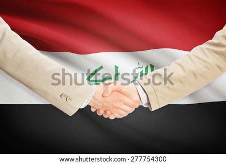 Businessmen shaking hands with flag on background - Iraq