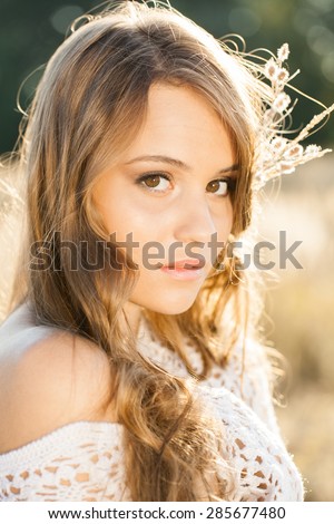 Portrait of young beautiful model in open field at sunrise