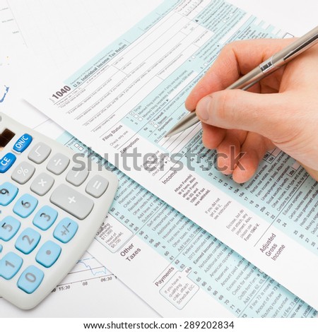 Male filling out US 1040 Tax Form - close up shot
