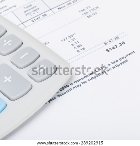 Calculator with utility bill under it - close up shot