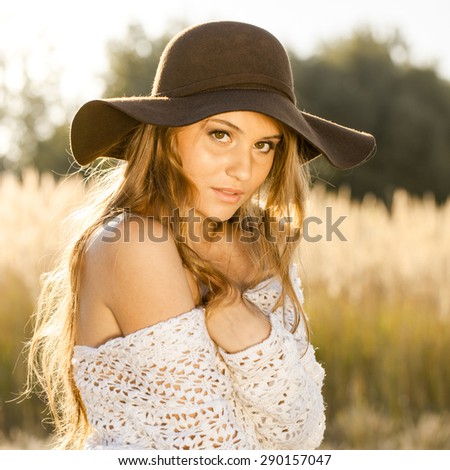 Beautiful model in open field at sunrise - outdoors shot