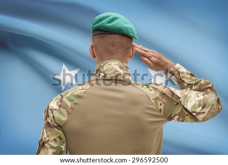 Dark-skinned soldier in hat facing national flag series - Micronesia