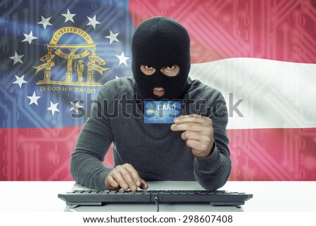 Dark-skinned hacker with credit card and USA states flag on background - Georgia