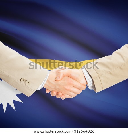 Businessmen shaking hands with flag on background - Nauru
