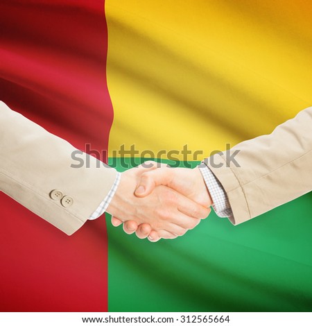 Businessmen shaking hands with flag on background - Guinea-Bissau