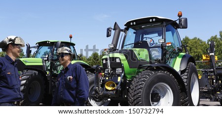 farmer and mechanic with large tractors in background, latest models