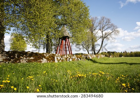 old bell tower and stone hedge, set in a rural landscape, culture from Sweden