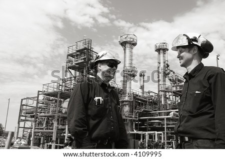 engineers in front of oil-refinery and in a silver duplex toning concept