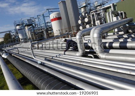 giant pipelines leading to oil-refinery, engineer working with main-pipes