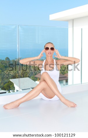 Fashion woman sitting at balcony with a ocean view