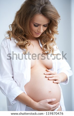 Happy young pregnant woman on natural background