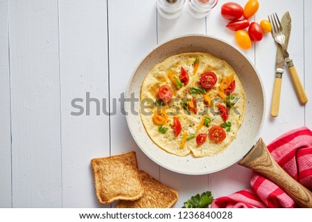Delicious homemade egg omelette with tomatoes and parsley. Sprinkled with fresh pepper. Served with toasts. Top view with copy space. Stock fotó © 