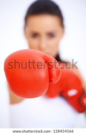 Close up of boxing glove with blurred silhouette of a woman