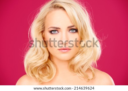 Beautiful blond woman with a quirky expression looking directly at the camera