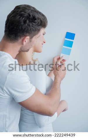 Middle Age Caucasian Couple Looking at Color Indicator Paper.Together Isolated on Very Light Blue Wall Background.
