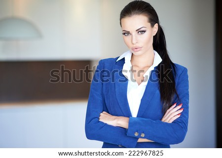 Confident Pretty Young Businesswoman with Crossed Arms in Blue Long Sleeve  Looking at Camera. Captured Indoor.