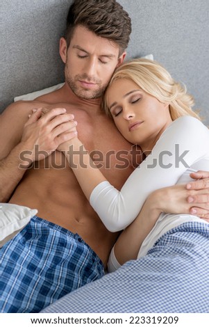 Romantic Middle Age Sexy Couple Sleeping on Bed with Gray Wall Background.