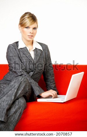Young women is resting on the couch and surfing the internet on her laptop computer