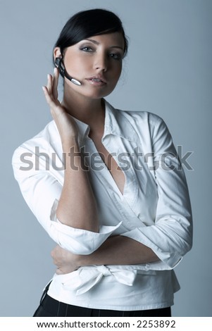 Beautiful brunette business woman with wireless headset isolated on clear background