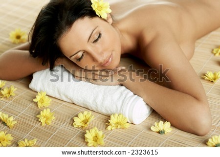 Portrait of Fresh and Beautiful brunette woman laying on bamboo mat around yellow flowers