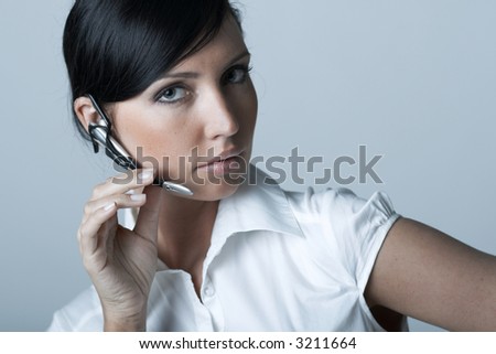 Beautiful and sexy brunette business woman talking telephone. She is isolated on clear background