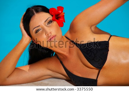 Beautiful young Sexy woman laying in bikini during sunbath next to swimming pool