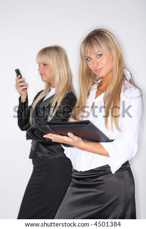 Two beautiful and sexy blond business women isolated on clear background