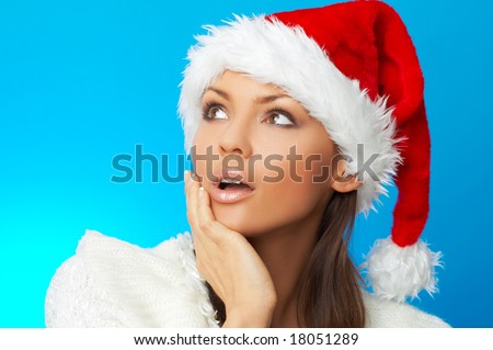 20-25 years old beautiful woman in Santa Claus hat on blue