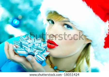 Beautiful young woman wearing santa hat next to christmas tree on white background