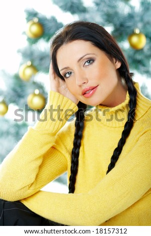 Beautiful brunette woman next to christmas tree on white background