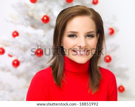 Beautiful woman next to christmas tree wearing red sweater