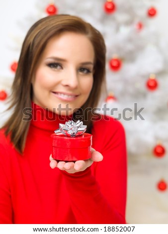 Beautiful woman next to christmas tree wearing red sweater