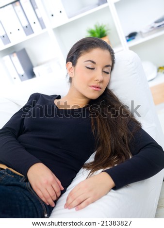 Young woman sleeping on couch at her home