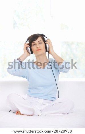 Young woman on couch and listen to the music