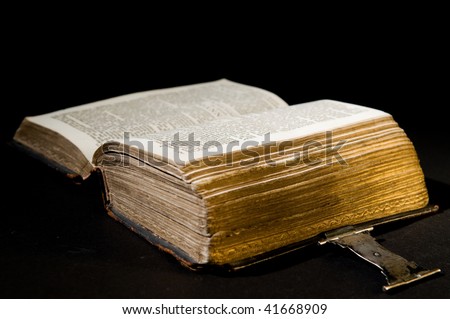 Nice old bible with an old lock on a black background.