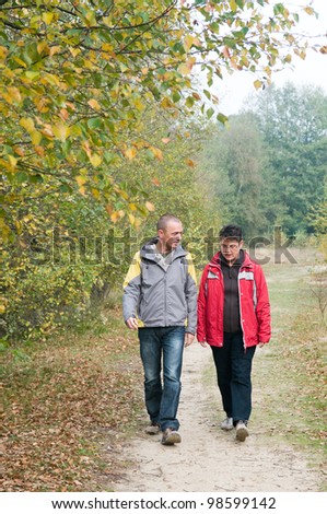 Man and a woman having a walk in the forest.