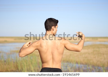 male bodybuilder model back view. outdoors background
