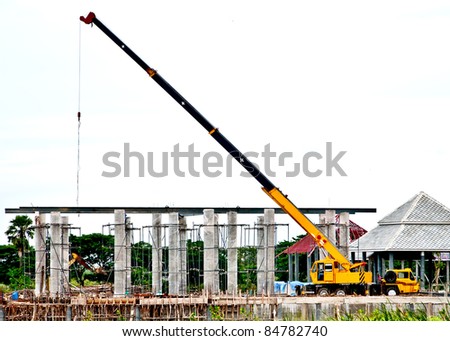 The yellow automobile crane lifted equipment for under construction