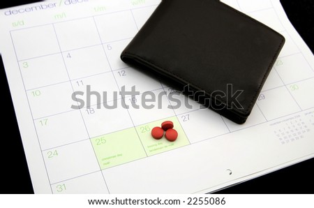 A wallet and headache pills highlight the stress of holiday spending.