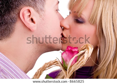young man kissing his girlfriend with red rose, isolated on white background