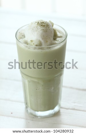 glass of green tea smoothies decorate with milk
