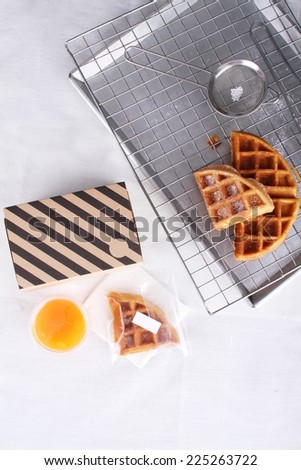 stacked homemade waffles on sieve and paper box