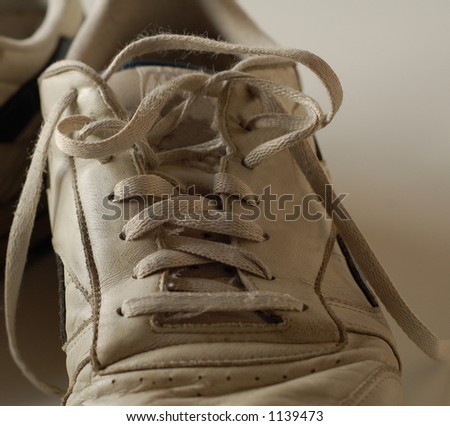 Dirty old running shoe with laces undone