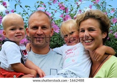 Happy family: parents with their kids in the garden