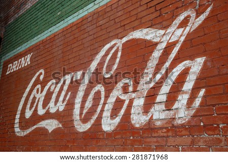 Brick wall painted with fading logo Coca-Cola in Wallis, Texas. May 2015
