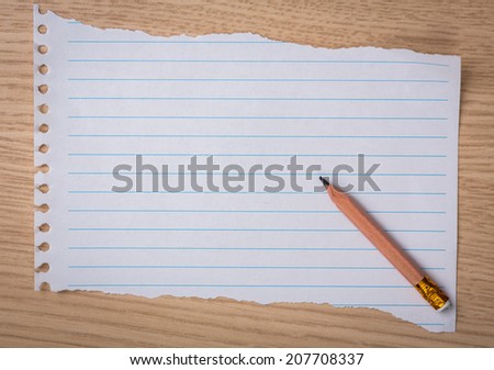 White note book paper with  pencil on a wooden desk