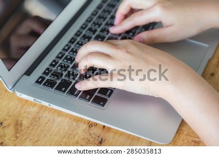 Closeup of business woman hand typing on laptop keyboard