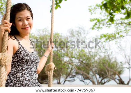Girl sitting on rope swings on the beach