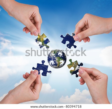 Business concept with a hand building puzzle globe