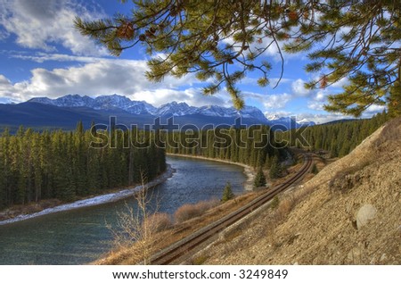 Bow river in the rocky mountains, railway tracks following the river.